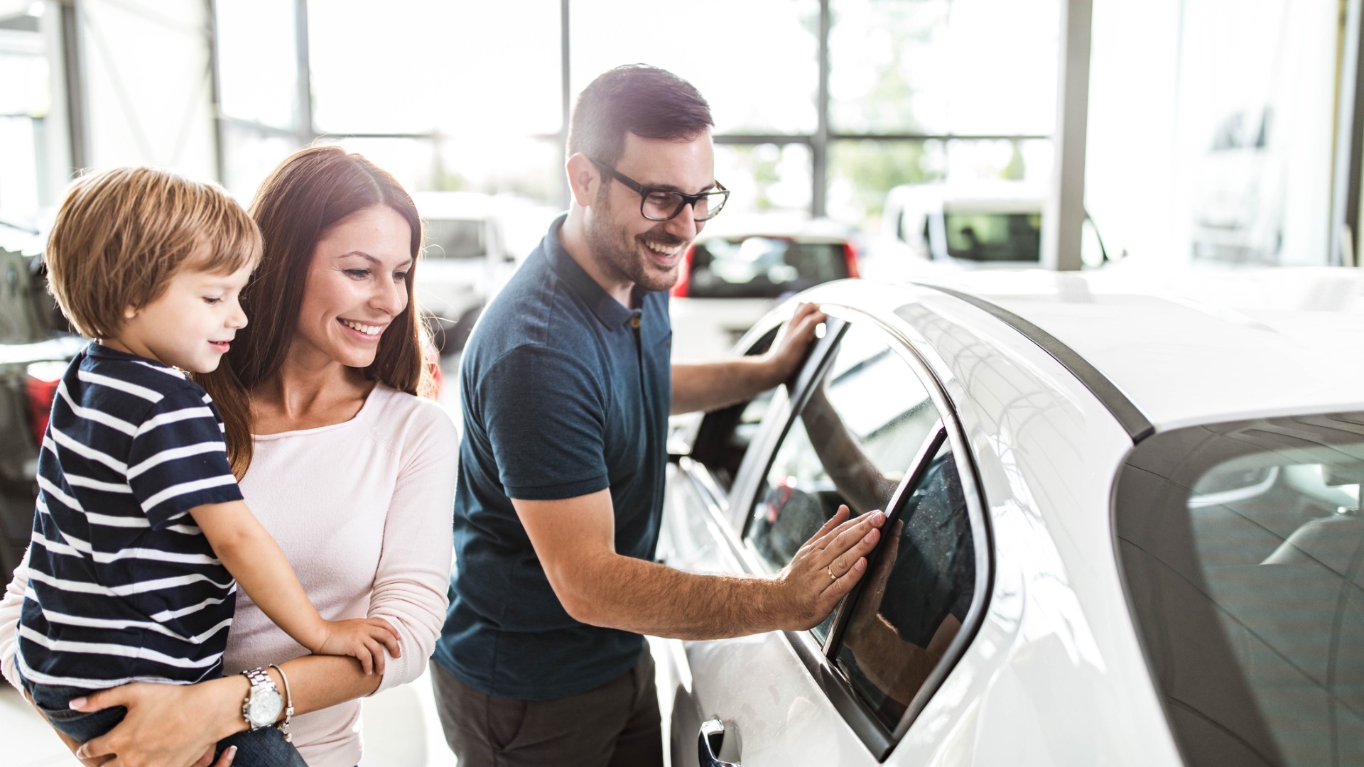 Family looking at new car in dealership - Buying a New Vehicle – Glass Coverage or No Coverage?